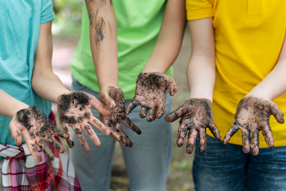 Crianças com as mãos sujas após uma plantação